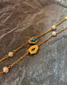 Detail of 18K gold chain with freshwater pearls, turquoise pendant and crystal accents