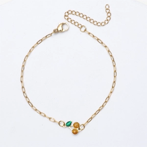 Detailed macro of 18K gold plated chain bracelet with a cherry charm and lobster clasp