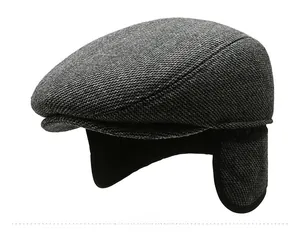 Detail view of winter flat cap showing ear flaps and grey herringbone wool texture