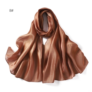 Detailed macro shot of brown satin silk scarf with premium glossy metallic texture
