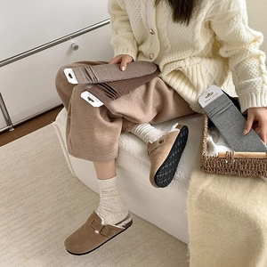 Cozy knit cotton crew socks in warm earth tones paired with suede clogs in a home setting