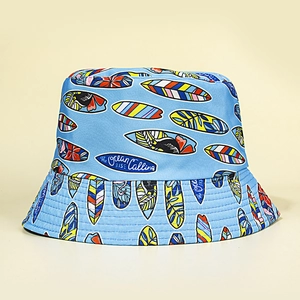 Light blue reversible bucket hat with colorful surfboard patterns and ocean text print