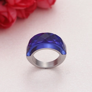 Chunky stainless steel ring with large faceted navy blue glass gemstone on pink surface