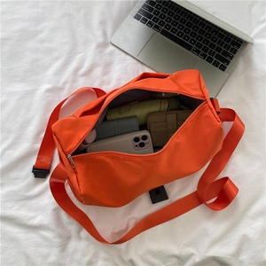 Orange Oxford fabric crossbody shoulder bag on bed showing large capacity and daily storage