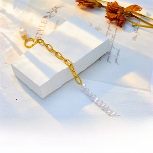 Detail of gold chain pearl bracelet with OT buckle and matte metallic texture