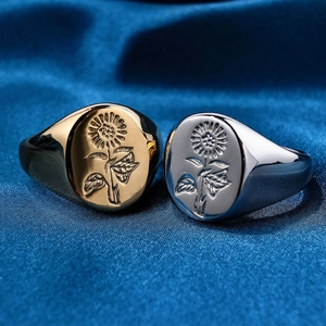 Detail of gold and silver stainless steel rings with sunflower floral engraving