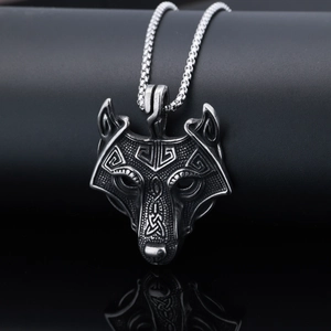 Detail of viking wolf head pendant with celtic patterns on a square pearl chain