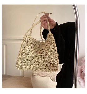 Detail of hand-woven straw bag with intricate floral crochet patterns for summer vacation