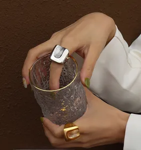 Detailansicht der Fingerabdruck-Textur auf quadratischen Siegelringen in Gold und Silber