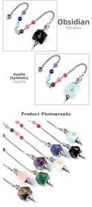Macro detail of chakra healing pendulums in obsidian and opalite with metal chains