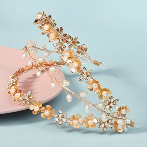 Detailed macro view of two gold floral headbands with white pearls and crystals
