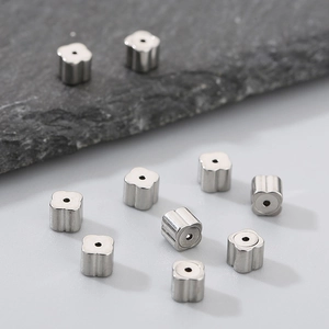 Detailed macro view of clover shaped silver stainless steel beads for DIY jewelry making