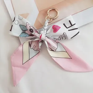 Detail of pink camellia silk bow keychain with love lettering and golden lobster clasp