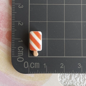 Gros plan d'une glace miniature en résine de 1,9cm avec échelle de mesure précise