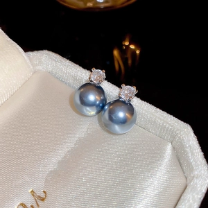 Détail macro de boucles d'oreilles perles gris-bleu et zircon argent sur soie