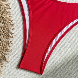 Detailed close-up of vibrant red bikini bottom with double stitching and white lining