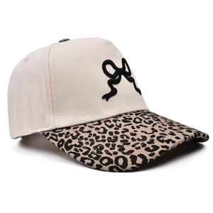 Dettaglio del fiocco ricamato 3D su cappellino in tela crema con visiera leopardata