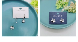 Detail view of silver flower earrings with zircon insets on white display cards
