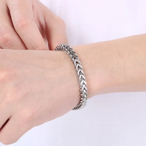 Macro shot of silver stainless steel Franco chain bracelet with minimalist square buckle