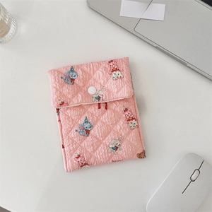 Detailed shot of pink quilted sanitary bag with animal prints on minimalist desk