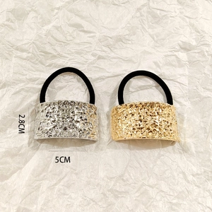 Detail of hammered metal hair ties in gold and silver showing 5cm x 2.8cm dimensions