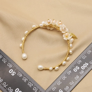 Handmade floral pearl bracelet with golden wire and white petals on silk