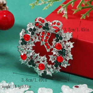 Macro view of Christmas wreath brooch with red and green rhinestones and bow detail