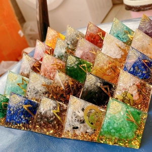 Detailed view of handmade Orgone pyramids with colorful healing crystals and gold foil
