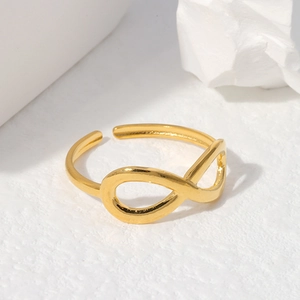 Minimalist gold infinity stainless steel open ring on a textured white background
