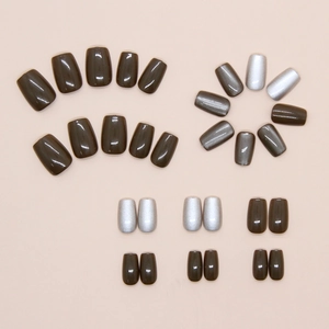 Detailed flat lay of short square cat eye press-on nails in olive green and silver grey