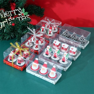 Close-up of Christmas candle gift sets featuring Santa Claus and snowman wax figures