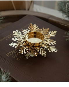 Golden snowflake candle holder on vintage books with pine needles for holiday decor
