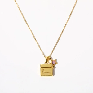 Detail of gold moon crescent locket and star pendant with pink zirconia stone