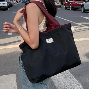 Eco-friendly black nylon tote bag with burgundy straps for daily commute shopping