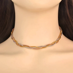 Detail of three-tone braided herringbone snake chain necklace in gold, silver, and rose gold