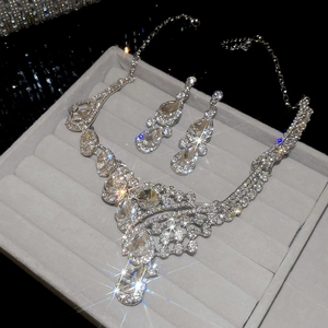 Macro shot of silver crystal necklace and earrings set in a grey velvet jewelry box