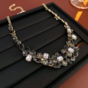 Détail du collier goutte vintage avec cristaux noirs et monture dorée élégante