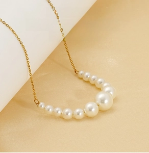 Close-up of elegant gold stainless steel chain with gradient white pearls detail