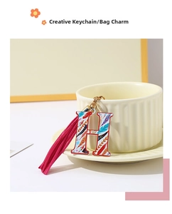 Detail of colorful letter H keychain with vibrant pink tassel and intricate patterns