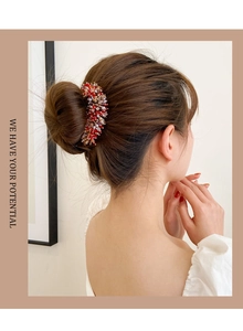 Detail of elegant crystal hair bun clip with red and clear rhinestones on elegant hair