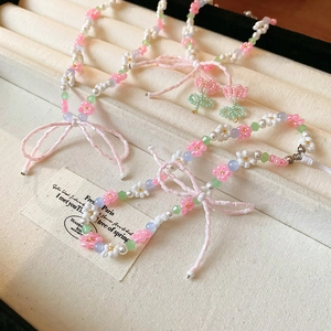 Floral seed bead necklace with white pearls and a pink bow tassel for a sweet aesthetic