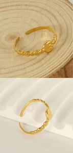 Vue détaillée d'une bague dorée réglable avec gravures florales et pièce ovale