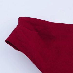 Close-up of red linen fabric showing detailed woven texture and edge stitching