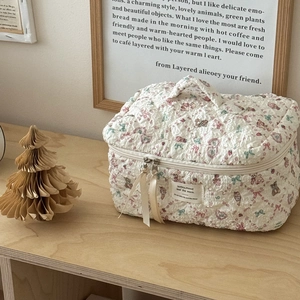 Close-up of floral quilted makeup bag featuring bear patterns and silk ribbon zippers