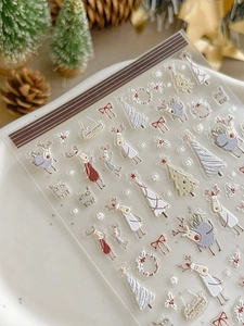 Detail view of 3D embossed Christmas nail stickers featuring reindeer and holiday motifs
