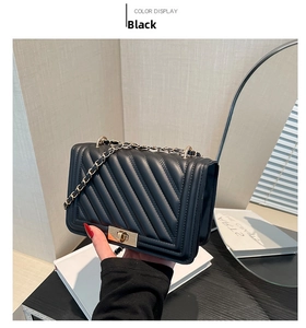 Close-up of black quilted leather shoulder bag featuring gold chain and turn-lock