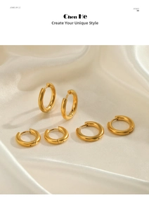 Close-up of three pairs of gold geometric hoop earrings on ivory satin fabric