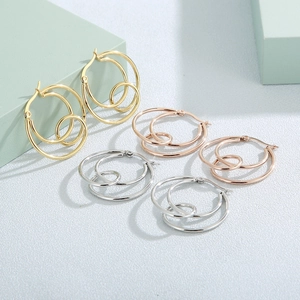 Three pairs of interlocking geometric knot hoop earrings in gold, silver, and rose gold