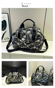 Detail of large black travel bag with skull and rose pattern showing pockets and strap