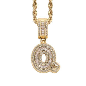 Detail of golden hip hop letter Q pendant with baguette and round cut cubic zirconia